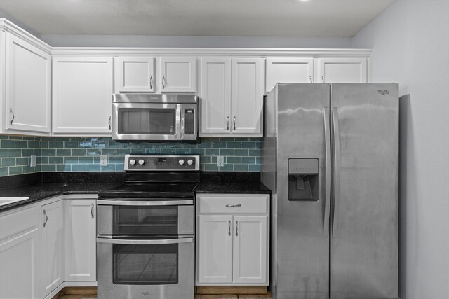 805 S Benson Pl, Nixa, MO 65714 - kitchen with appliances with stainless steel finishes, white cabinetry, tasteful backsplash, and dark stone countertops