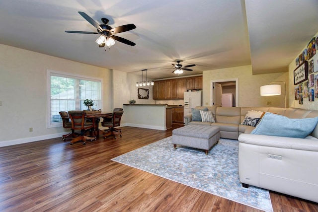 living room with a ceiling fan, baseboards, and dark wood-style flooring