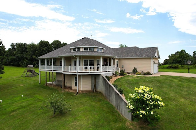 rear view of house featuring a yard, a garage, concrete driveway, and a playground