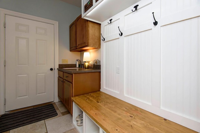 mudroom featuring a sink and light tile patterned floors