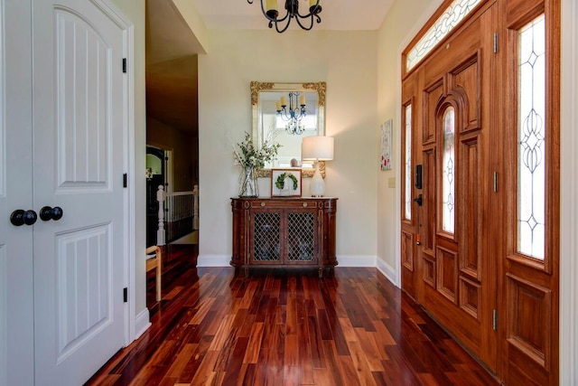 entryway with a chandelier, dark wood-type flooring, and baseboards