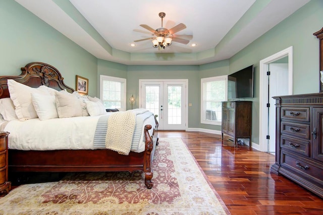 bedroom featuring access to exterior, wood finished floors, a raised ceiling, recessed lighting, and baseboards
