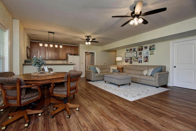 living room featuring ceiling fan and dark wood finished floors