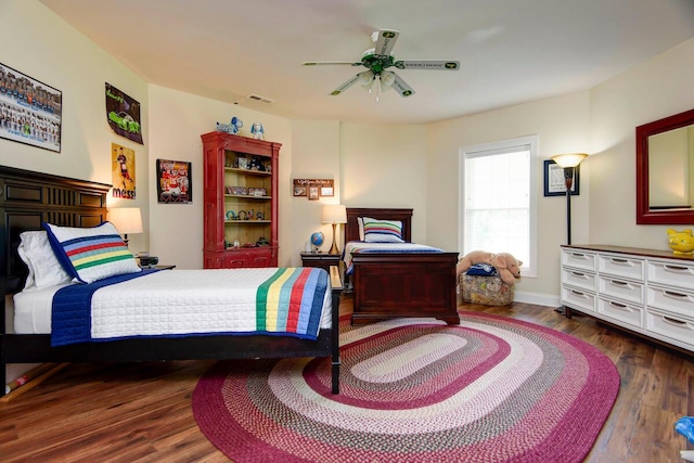 bedroom with wood finished floors, a ceiling fan, and baseboards