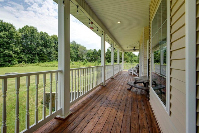 wooden terrace featuring a porch and a lawn