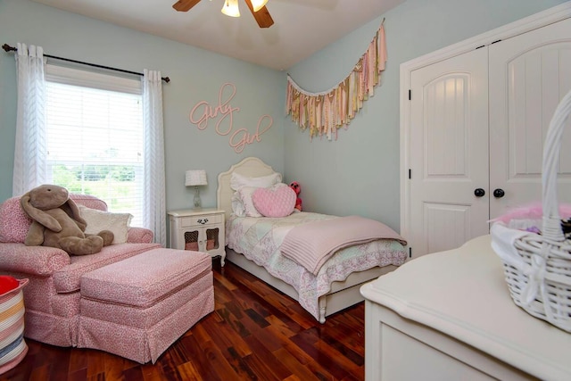 bedroom with dark wood-style flooring, a closet, and a ceiling fan