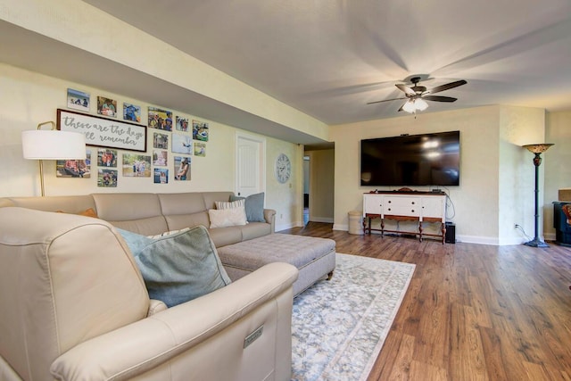 living area with ceiling fan, baseboards, and wood finished floors