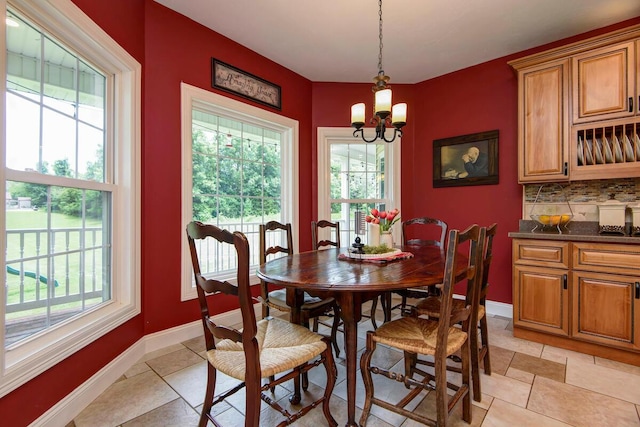 dining room with baseboards and a chandelier
