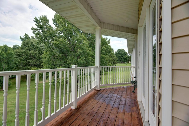 wooden deck featuring a lawn
