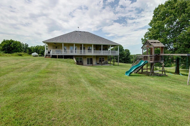 back of property with a yard, a playground, and a deck
