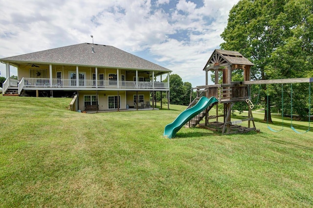 rear view of house featuring a yard, a deck, and roof with shingles