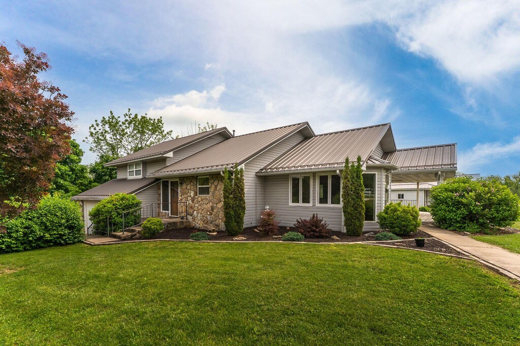 185 Pioneer Dr, Seymour, MO 65746 - tri-level home with a front yard, stone siding, and metal roof