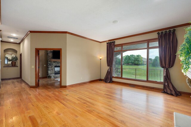 6046 S Parkhaven Ln, Springfield, MO 65810 - empty room featuring crown molding, a fireplace, baseboards, and light wood-style flooring