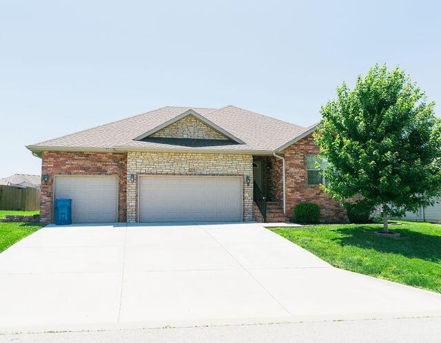1205 N 12th Ave, Ozark, MO 65721 - view of front of home featuring a front lawn, a garage, and driveway