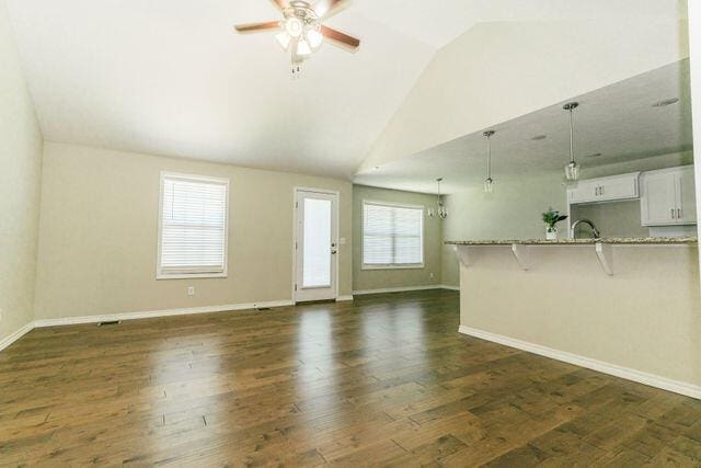 1205 N 12th Ave, Ozark, MO 65721 - unfurnished living room featuring vaulted ceiling, a ceiling fan, and dark wood-type flooring