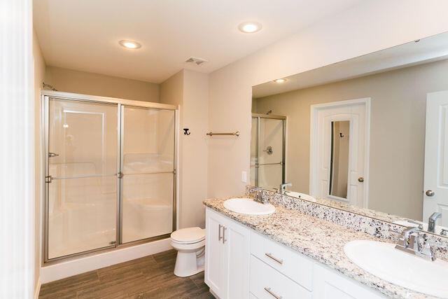 1205 N 12th Ave, Ozark, MO 65721 - bathroom with a stall shower, double vanity, wood finished floors, and recessed lighting