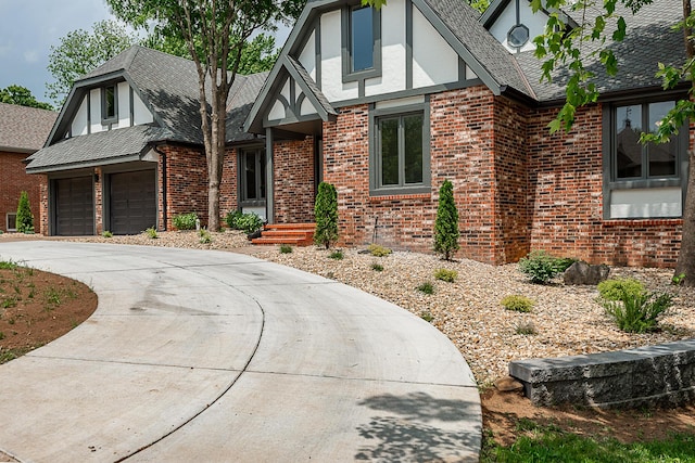 1935 E Canterbury St, Springfield, MO 65804 - english style home featuring brick siding, curved driveway, a garage, and stucco siding
