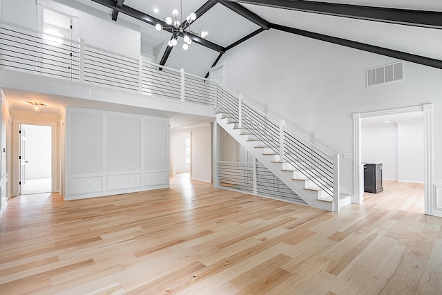 1935 E Canterbury St, Springfield, MO 65804 - unfurnished living room with high vaulted ceiling, stairway, light wood finished floors, beam ceiling, and a chandelier