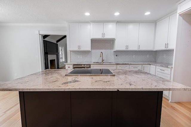 1935 E Canterbury St, Springfield, MO 65804 - kitchen featuring a sink, light wood finished floors, backsplash, white cabinets, and recessed lighting