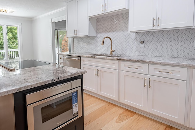 1935 E Canterbury St, Springfield, MO 65804 - kitchen featuring a sink, stainless steel appliances, ornamental molding, and white cabinetry