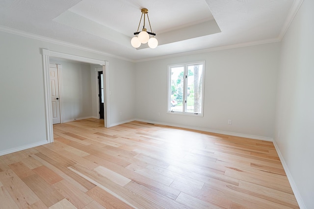 1935 E Canterbury St, Springfield, MO 65804 - empty room featuring light wood finished floors, a tray ceiling, baseboards, a chandelier, and crown molding