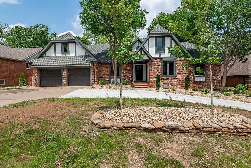 1935 E Canterbury St, Springfield, MO 65804 - english style home featuring driveway, a garage, and brick siding