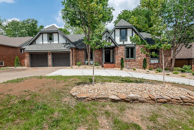 1935 E Canterbury St, Springfield, MO 65804 - tudor-style house with concrete driveway, an attached garage, and brick siding