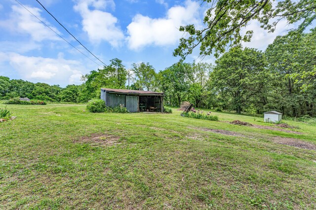 3152 Two Rivers Rd, Highlandville, MO 65669 - view of green lawn featuring an outbuilding, a pole building, a storage shed, and a view of trees