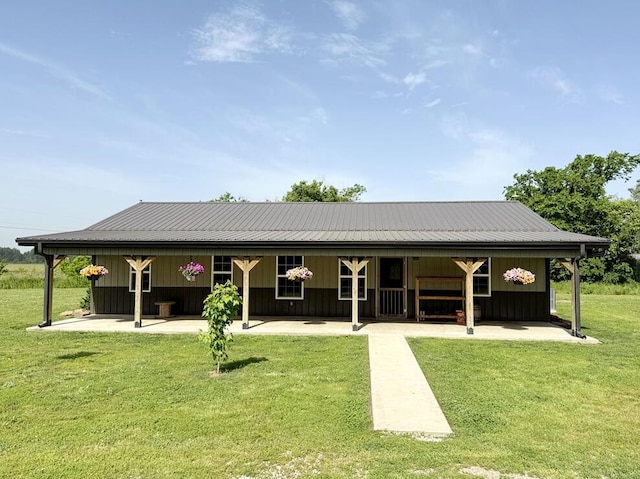 30285 E Pawhuska Rd, El Dorado Springs, MO 64744 - back of property with metal roof, a patio area, board and batten siding, and a yard