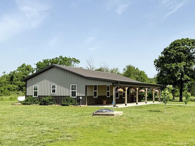 30285 E Pawhuska Rd, El Dorado Springs, MO 64744 - back of property with a lawn, an outdoor fire pit, and board and batten siding