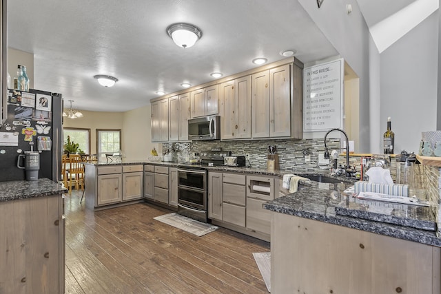 45 Stone Ridge Ct, Strafford, MO 65757 - kitchen with stainless steel appliances, a peninsula, a sink, dark wood-type flooring, and decorative backsplash