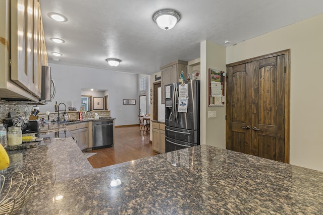 45 Stone Ridge Ct, Strafford, MO 65757 - kitchen featuring stainless steel appliances, dark wood finished floors, a sink, a peninsula, and backsplash