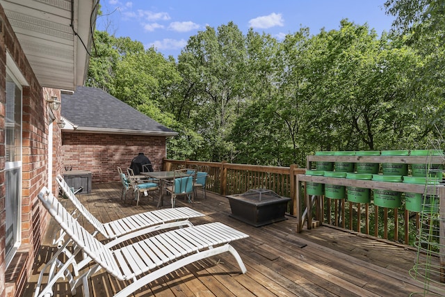 45 Stone Ridge Ct, Strafford, MO 65757 - wooden deck with outdoor dining area, a fire pit, and view of wooded area