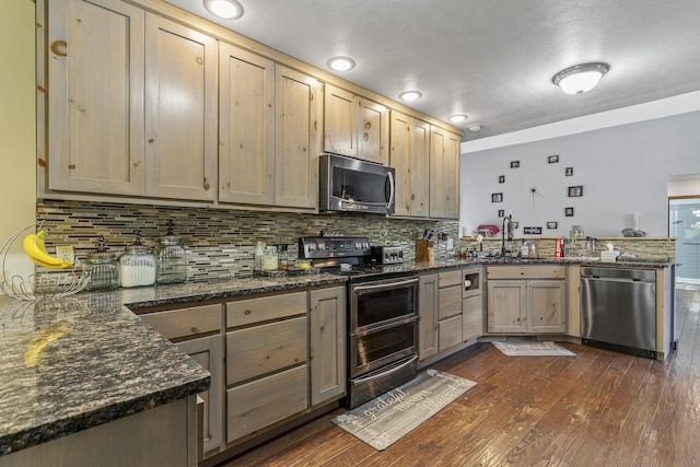 45 Stone Ridge Ct, Strafford, MO 65757 - kitchen featuring appliances with stainless steel finishes, a peninsula, dark wood finished floors, tasteful backsplash, and a sink