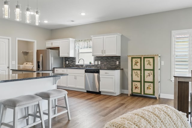 233 Siena Blvd, Branson, MO 65616 - kitchen featuring stainless steel appliances, white cabinetry, a kitchen breakfast bar, backsplash, and a sink