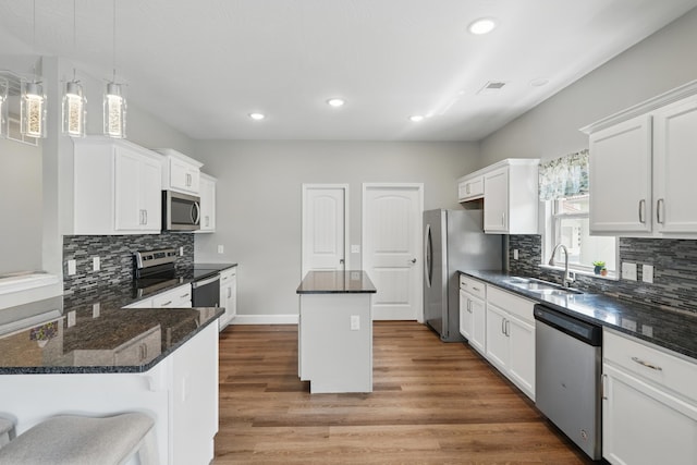 233 Siena Blvd, Branson, MO 65616 - kitchen with appliances with stainless steel finishes, a center island, a sink, backsplash, and recessed lighting