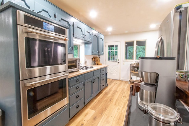 5312 S Hawthorne Dr, Springfield, MO 65804 - kitchen featuring double oven, light wood-type flooring, light countertops, recessed lighting, and gray cabinetry