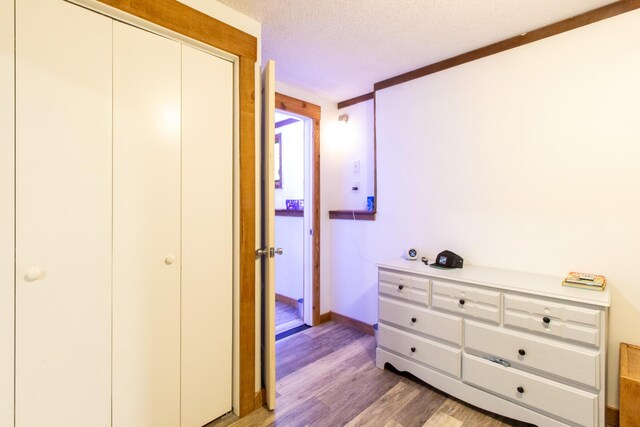 5312 S Hawthorne Dr, Springfield, MO 65804 - bedroom featuring light wood finished floors, a textured ceiling, baseboards, and a closet