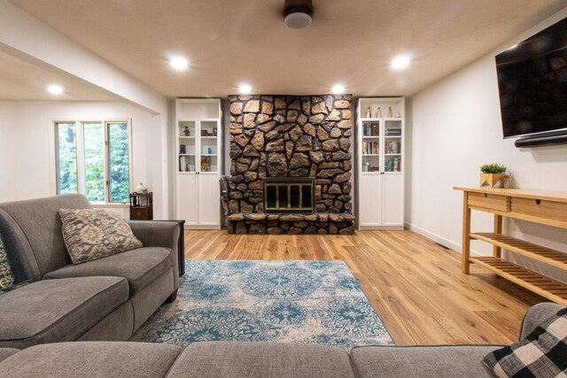 5312 S Hawthorne Dr, Springfield, MO 65804 - living area featuring wood finished floors, recessed lighting, a stone fireplace, and baseboards