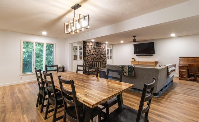 5312 S Hawthorne Dr, Springfield, MO 65804 - dining room featuring light wood-style flooring, a ceiling fan, recessed lighting, a stone fireplace, and baseboards