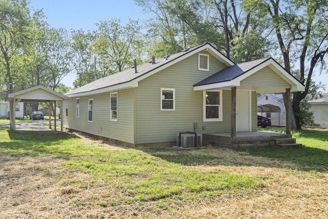 1827 N Tyler Ave, Springfield, MO 65802 - back of property with a yard, a carport, roof with shingles, and central AC