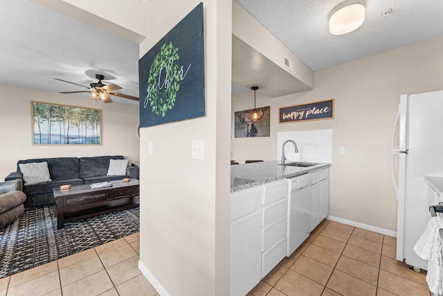 13 Treehouse Ln Unit 4, Branson, MO 65616 - kitchen with white appliances, a sink, a textured ceiling, light tile patterned flooring, and white cabinetry