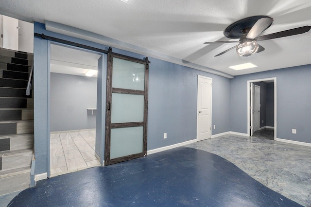 2418 E Catalpa St, Springfield, MO 65804 - empty room featuring a barn door, a ceiling fan, stairs, baseboards, and a textured ceiling