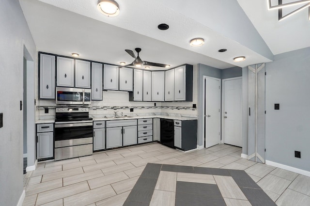 2418 E Catalpa St, Springfield, MO 65804 - kitchen featuring stainless steel appliances, gray cabinets, light countertops, a sink, and decorative backsplash