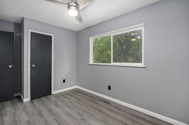 2418 E Catalpa St, Springfield, MO 65804 - unfurnished bedroom with wood finished floors, baseboards, and a ceiling fan