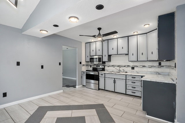 2418 E Catalpa St, Springfield, MO 65804 - kitchen featuring appliances with stainless steel finishes, ceiling fan, a sink, tasteful backsplash, and gray cabinets