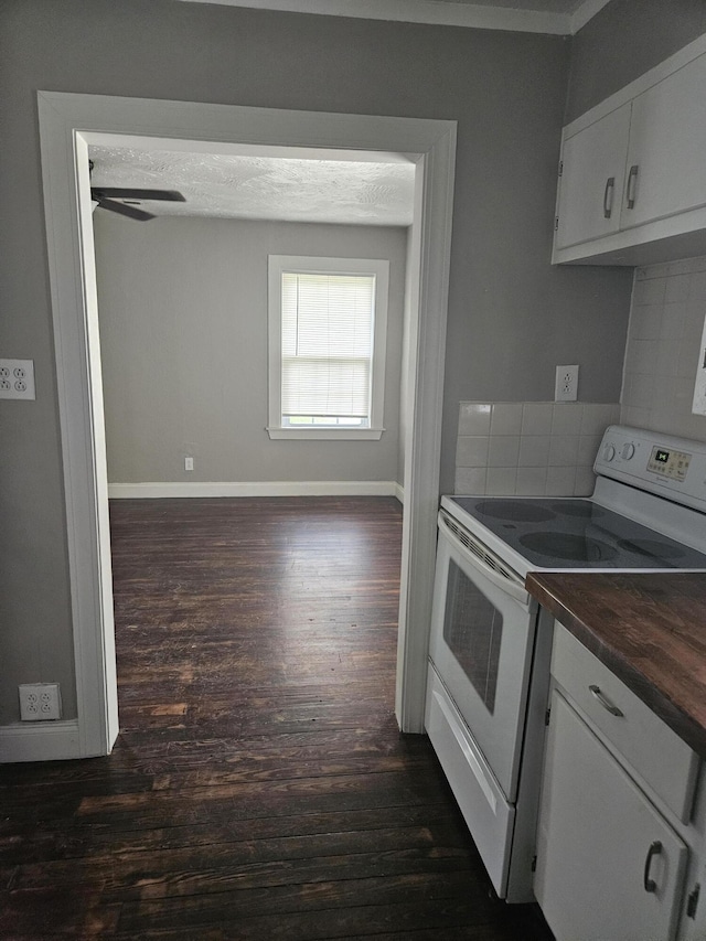 1629 W Webster St, Springfield, MO 65802 - kitchen featuring white electric range, dark wood-type flooring, dark countertops, backsplash, and white cabinetry