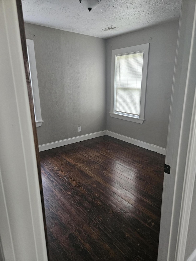 1629 W Webster St, Springfield, MO 65802 - spare room with dark wood-style floors, a textured ceiling, and baseboards