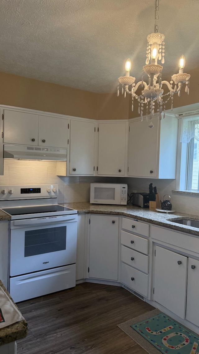 kitchen featuring white appliances, under cabinet range hood, dark wood-style flooring, white cabinetry, and a sink