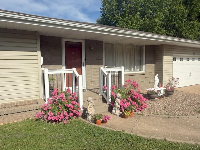 view of front facade with covered porch, brick siding, an attached garage, and driveway